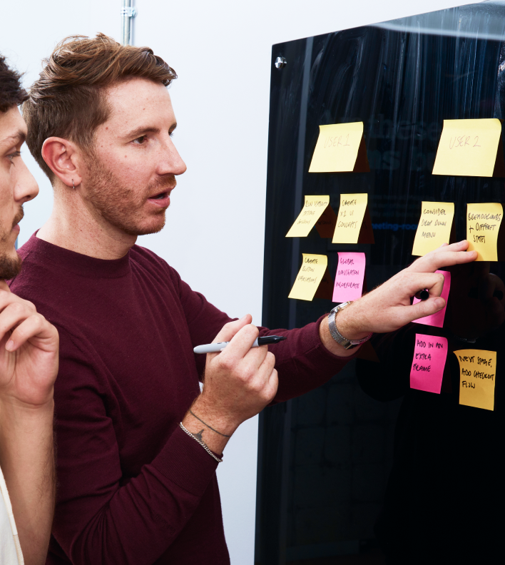 People in front of board with post it